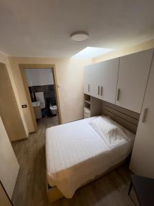 a bedroom with a white bed and a mirror at El Rocol in Vezza dʼOglio