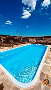 a blue swimming pool with a blue sky in the background at Tisno Resort in Tisno
