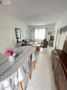 eine Küche und ein Wohnzimmer mit einem Tisch mit Blumen darauf in der Unterkunft Au Bon Port - Maison Bel Air in Les Sables-dʼOlonne