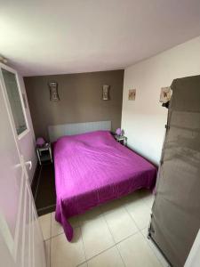 ein Schlafzimmer mit einem lila Bett in einem Zimmer in der Unterkunft Au Bon Port - Maison Bel Air in Les Sables-dʼOlonne