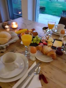 uma mesa de madeira com comida e bebidas para o pequeno-almoço em De Zevende Zon em Poperinge