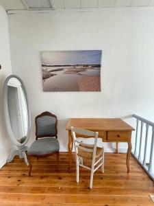 einen Schreibtisch und einen Stuhl in einem Zimmer mit einem Bild an der Wand in der Unterkunft Au Bon Port - Maison Bel Air in Les Sables-dʼOlonne