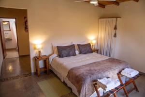 a bedroom with a large bed with two lamps at Tinku in Tilcara