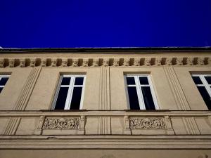 un edificio con tres ventanas y un cielo azul en Jizerské apartmány Ha&Ha, en Janov nad Nisou