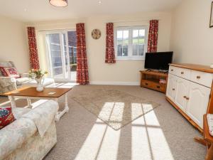 a living room with a couch and a tv at Holly Cottage in Ventnor