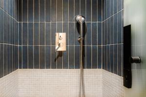 eine Dusche im Bad mit blauen Fliesen in der Unterkunft PAREA Athens in Athen
