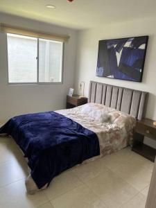 1 dormitorio con cama y ventana en Departamento en La joya full, en Guayaquil