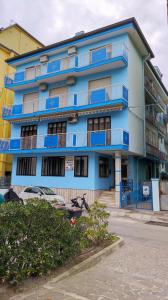a blue building with blue balconies on a street at Appartamenti Padoan in Sottomarina