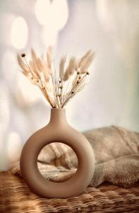 a white vase with some dried flowers in it at Landhotel Sonnenhof in Siebeldingen