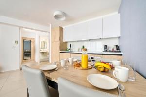 烏馬格的住宿－Royal Blue Suite，厨房以及带木桌和椅子的用餐室。