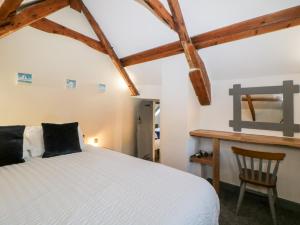 a bedroom with a white bed and a wooden desk at Eventide in Plymouth