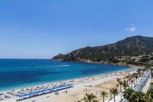 a beach with a bunch of people and the ocean at KAKTUS Hotel Kaktus Albir in Albir