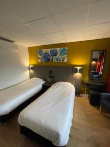 a hotel room with two beds and a desk at City Hotel Tilburg in Tilburg