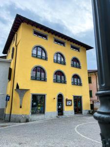 a yellow building with many windows on it at El Rocol in Vezza dʼOglio