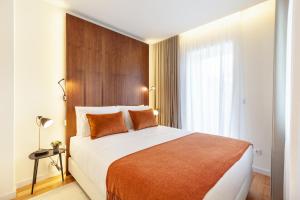 um quarto com uma cama grande e uma janela grande em Sé Apartamentos - Avenida Residence em Braga