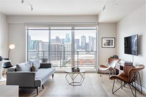 a living room with a couch and a large window at Locale Victory Park - Dallas in Dallas