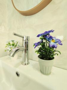 a bathroom sink with a vase of flowers on it at Ipoh Lake View Cozy Home Big House in Lahat