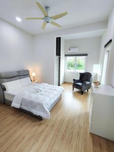 a white bedroom with a bed and a ceiling fan at Ipoh Lake View Cozy Home Big House in Lahat