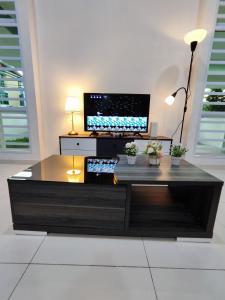 a coffee table in a living room with a flat screen tv at Ipoh Lake View Cozy Home Big House in Lahat