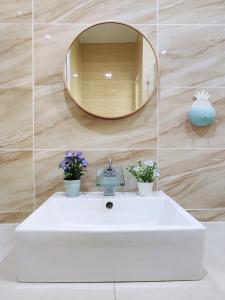 La salle de bains est pourvue d'un lavabo blanc et d'un miroir. dans l'établissement Ipoh Lake View Cozy Home Big House, à Lahat