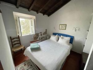 um quarto com uma cama branca e uma janela em Casalinho do Farol em Setúbal