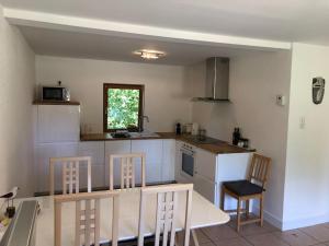 a kitchen with a table and chairs and a kitchen with a counter at La Mouette Rose - a zen guest-house in Lauterbourg 