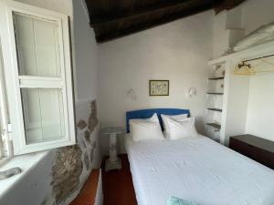 Casalinho do Farol في سيتوبال: غرفة نوم صغيرة بها سرير ونافذة