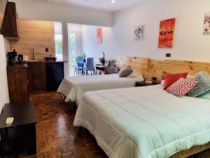 - une chambre avec 2 lits, une table et des chaises dans l'établissement Casa Jardin del Mango, à San José