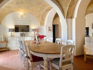Il comprend une cuisine et une salle à manger avec une table et des chaises en bois. dans l'établissement Villa dei Trabocchi - Accogliente casale per famiglie che affaccia sul mare, à Ortona
