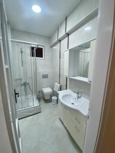 uma casa de banho com um lavatório, um chuveiro e um WC. em Şişli House em Istambul