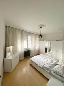 um quarto branco com uma cama grande e uma secretária em Şişli House em Istambul