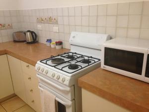 a kitchen with a white stove and a microwave at The Nosh & Nod - Avon Terrace in York