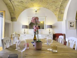 - une table avec des verres à vin et un vase avec des fleurs dans l'établissement Villa dei Trabocchi - Accogliente casale per famiglie che affaccia sul mare, à Ortona