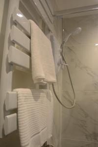 a bathroom with a shower and a white towel at Room at the Back, 2 George Street in Avoch