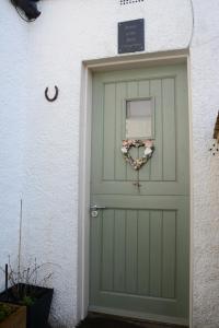 a green garage door with a heart wreath on it at Room at the Back, 2 George Street in Avoch
