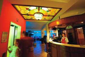 a woman and a child standing at a bar in a restaurant at Hotel Stanger in Lovran
