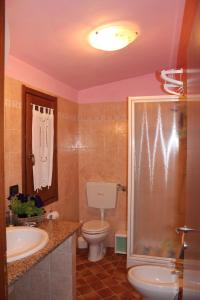 a bathroom with a toilet and a sink and a shower at Casetta Marieoria Chia in Chia