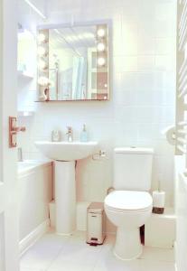 a white bathroom with a sink and a toilet at Fisherman's Cottage in Cockenzie