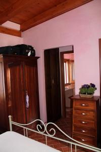 Schlafzimmer mit einem Bett, einer Kommode und einem Spiegel in der Unterkunft Casetta Marieoria Chia in Chia