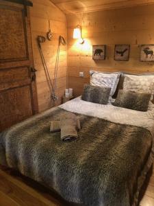 1 dormitorio con 1 cama grande en una cabaña en La Cabane du Trappeur, en Ore