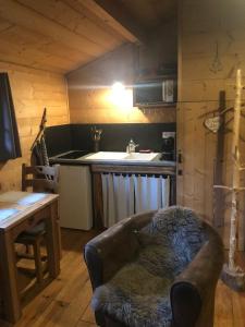 a living room with a couch and a table and a kitchen at La Cabane du Trappeur in Ore