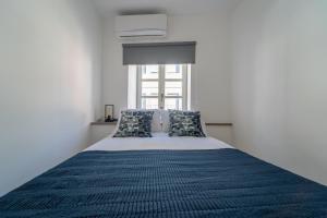 um quarto com uma cama com um edredão azul e uma janela em Casa Azul em Braga