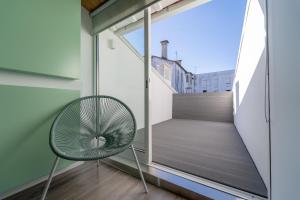 uma cadeira numa varanda com uma janela em Casa Azul em Braga