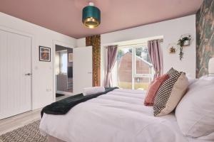 um quarto com uma grande cama branca e uma janela em Homebird Property - Ash Tree House em Leeds