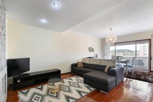 sala de estar con sofá y TV en Sé Apartamentos - Casa Cecília, en Braga