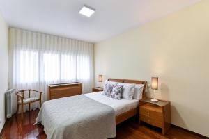 Un dormitorio con una cama grande y una ventana en Sé Apartamentos - Casa Cecília, en Braga