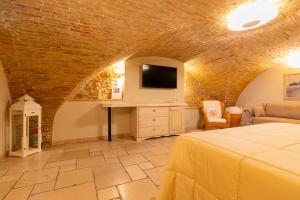 a bedroom with a bed and a tv on a brick wall at Residenza Sveva in Termoli
