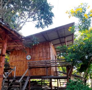 ein Holzhaus mit einer Bank davor in der Unterkunft Red orchid pai Thailand in Pai