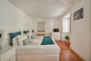 リスボンにあるCasa Portuguesa Calharizの白を基調としたベッドルーム(青色のアクセントが効いた大きな白いベッド1台付)