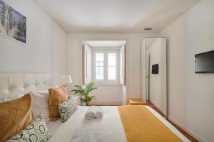 リスボンにあるCasa Portuguesa Calharizのベッドルーム(大きな白いベッド1台、窓付)